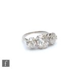 An early 20th Century platinum diamond three stone ring, old cut claw set stones, centre stone