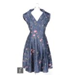 A 1950s ladies vintage dress in blue crepe satin with a printed pink rose bud pattern, v neck bodice