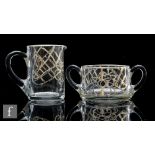 A 20th Century moulded clear crystal cream jug, with applied silvered stylised floral decoration,