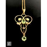 A 9ct Edwardian open work pendant set with two peridot stones, length 4.5cm, suspended from a