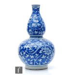 A Chinese blue and white double-gourd vase, the body with a rich cobalt ground, picked out with