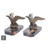A pair of 20th Century bookends, decorated with bronzed spelter stylised eagles, mounted to marble