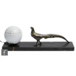 A French Art Deco table lamp decorated with a bronzed spelter peacock, with an opaque white sphere