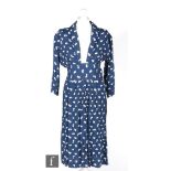 A 1940s ladies vintage dress in deep blue with a white abstract repeat pattern, three quarter