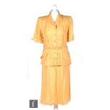 A late 1940s ladies vintage two piece safari suit in mustard yellow, the short sleeved belted jacket