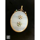 An 18ct mounted oval banded agate pendant, the central stone inset with two five stone opal clusters