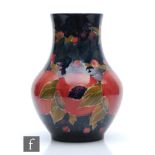 William Moorcroft - A baluster vase decorated in the Pomegranate pattern with a band of open and