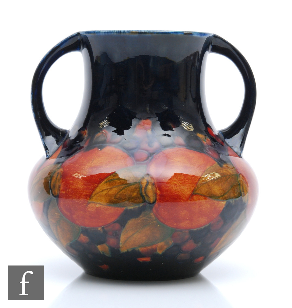 William Moorcroft - A twin handled vase decorated in the Pomegranate pattern with a band of whole