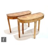 In the manner of Epstein - A pair of cross-banded walnut veneered console tables, with scalloped