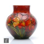 William Moorcroft - A small vase of globular form decorated in the Flambe Freesia pattern, impressed