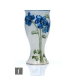 William Moorcroft - James Macintyre & Co - A miniature vase decorated in the Violet pattern with
