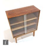 Chris Berry (1932–2014) - A 1950s walnut bookcase with sliding glazed double doors above chamfered