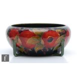 William Moorcroft - A large roll rim bowl supported by four angular feet decorated in the