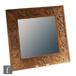 Unknown - An early 20th Century Arts and Crafts oak square bevelled edge mirror carved with roses