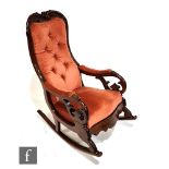An early Victorian rocking chair with exposed mahogany frame, with acanthus leaf top rail over