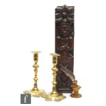An 18th Century carved caryatid oak panel, 45cm x 10cm, two 18th Century brass candlesticks and a