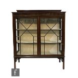 An Edwardian Chippendale style mahogany display cabinet enclosed by a pair of bar glazed doors below