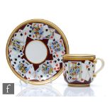 A 19th Century Minton cup and saucer decorated with transfer decorated and hand painted playing