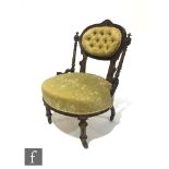 A Victorian walnut nursing chair with turned spindle uprights supporting an oval back, on turned