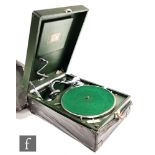 A portable gramophone, HMV model 102C, in green case with 5A soundbox, retains leather outer cover.