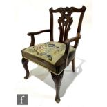 An early 20th Century Chippendale style mahogany elbow chair, the pierced vase splat below an