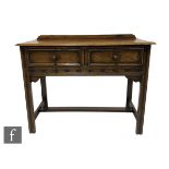 A small Jacobean revival light oak two drawer side table with ledge back, on square moulded legs