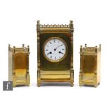 A late 19th and early 20th Century French brass clock garniture, the circular white enamelled dial