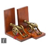 A pair of walnut 20th Century bookends each mounted with a brass field canon, green baize bases,