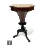 A Victorian octagonal sewing table, the hinged top opening to reveal a fitted interior on ebonised