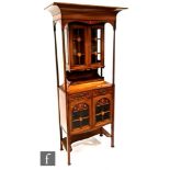 An Art Nouveau mahogany salon display cabinet, with cornice pediment over turned pillar supports a