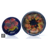 A Moorcroft Pottery footed bowl in the Hibiscus pattern against a blue ground, impressed marks,