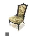 A Victorian carved walnut easy/nursing chair, splayed turned uprights on turned legs to the front,