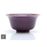 A Ruskin Pottery souffle glaze bowl, the whole in purple with a painted vine garland to the interior