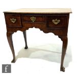 A George III oak and mahogany crossbanded lowboy, the three fitted drawers above a shaped apron,