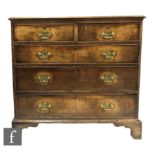 A George III oak straight front chest of two short and three long drawers, fret brass drop handles