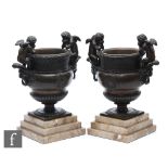 A pair of 20th Century bronze classical half fluted vases each mounted with two winged amorini in
