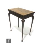 A 1920s figured walnut rectangular fold over card table, the moulded edge top over a plain frieze,