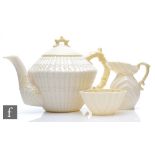 A Belleek Limpet shape teapot, milk jug and sugar bowl, all with yellow lustre detailing, 5th period