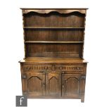 A 17th Century style oak dresser fitted with two lunette drawers over three fielded panel doors on