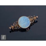 AMENDED DESCRIPTION An early 20th Century 9ct mounted carved opaque glass Man in the Moon brooch,