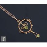 An early 20th Century 9ct two stone peridot open work pendant, suspended from a fetter link chain,