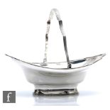 A hallmarked silver pedestal boat shaped swing basket of plain form terminating in reeded waved