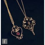 Two early 20th Century open work garnet and seed pearl set pendants, each missing stone drop, and