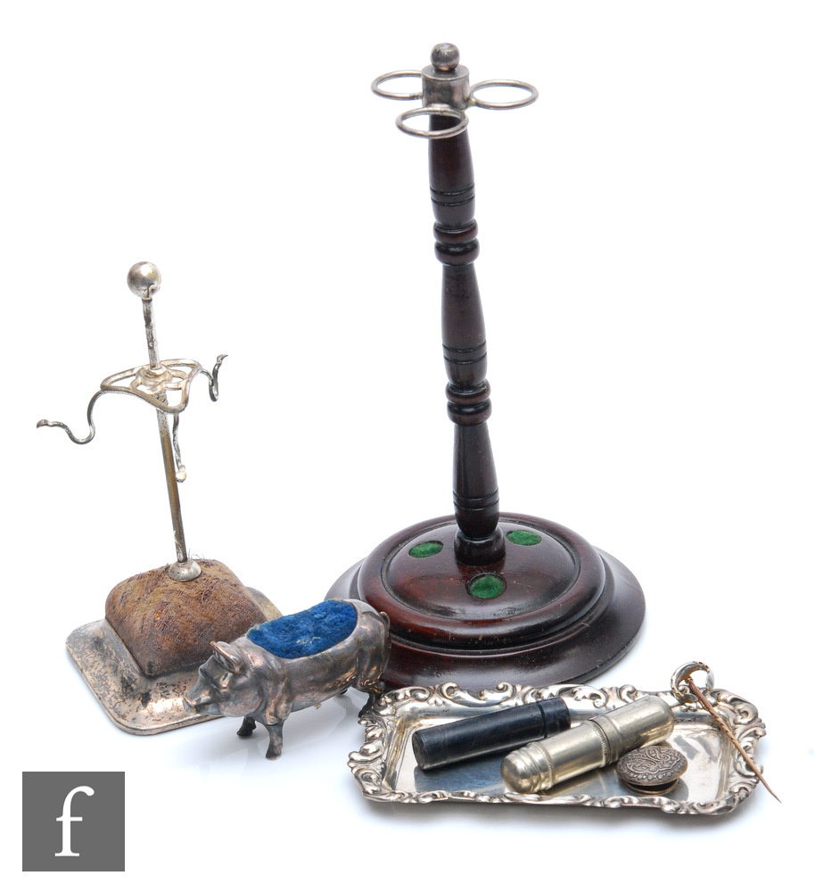 A silver plated hat pin stand with another turned wooden example, a Sterling silver pin tray, a