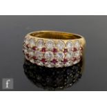 An 18ct ruby and diamond ring comprising three rows of seven graduated diamonds spaced by eight