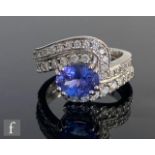 An 18ct hallmarked white gold tanzanite and diamond ring horizontal claw set oval tanzanite to