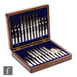 A cased set of twelve mother of pearl handled fruit knives and forks each with engraved foliate