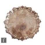 A George II hallmarked silver salver with later part foliate engraved decoration around central