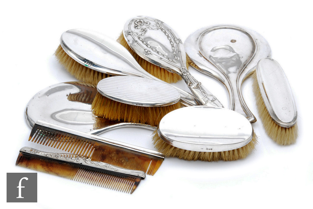 A parcel lot of hallmarked silver backed hair brushes, combs and hand mirrors, various styles and
