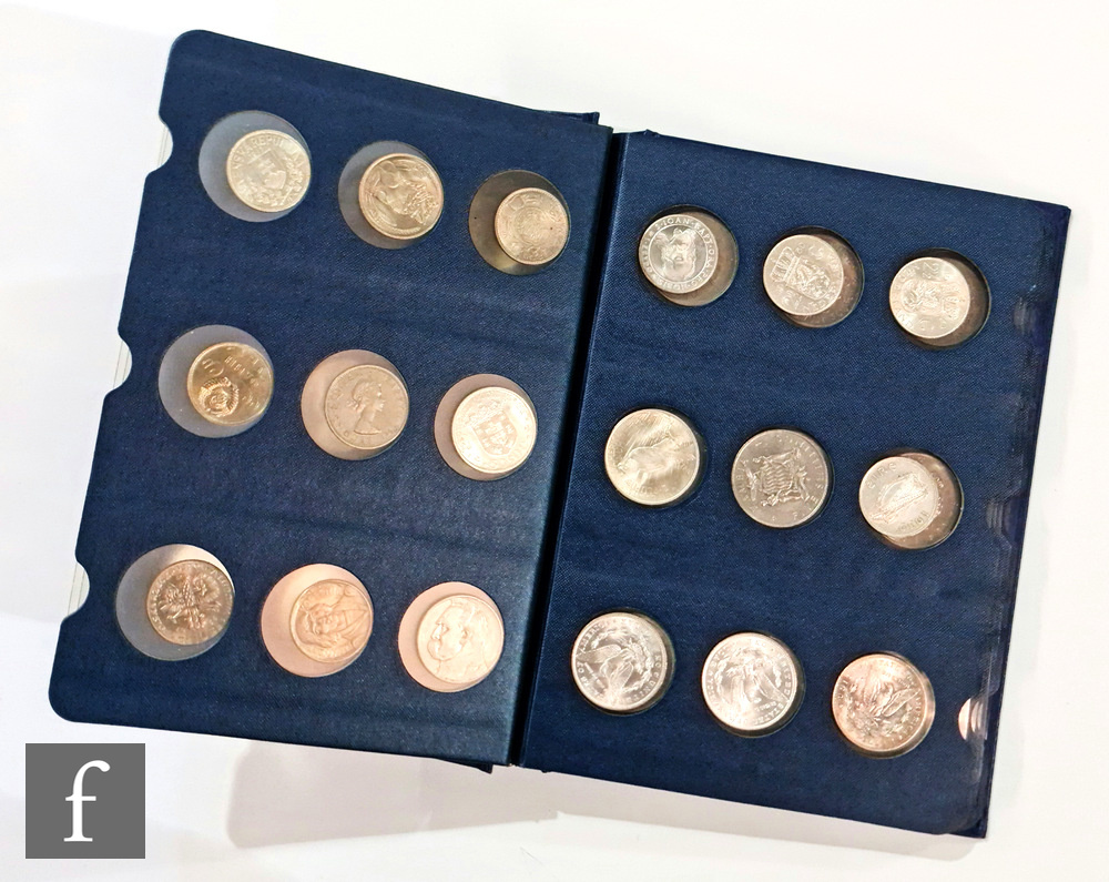 An album of coins from America, the Netherlands, Spain and South Africa, containing three Morgan